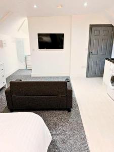 una camera da letto con un divano e una TV a schermo piatto di Flat 6 - Eign St Hereford a Hereford