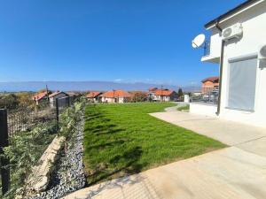a yard with green grass and a house at Villa Nova Ohrid in Ohrid