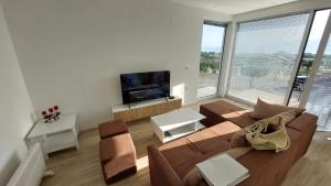 a living room with a couch and a large window at Villa Nova Ohrid in Ohrid