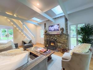 a living room with a fireplace and a tv at The Gingerbread House in Upper Tallebudgera