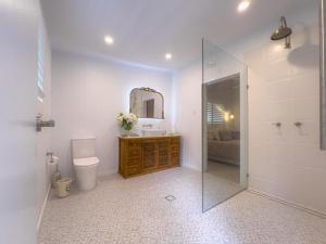 een badkamer met een toilet, een wastafel en een spiegel bij The Gingerbread House in Upper Tallebudgera +46 foto's