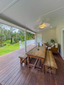 een groot terras met een houten tafel op een veranda bij The Gingerbread House in Upper Tallebudgera