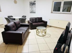 a living room with two couches and a tv at House AL11 in Raunheim
