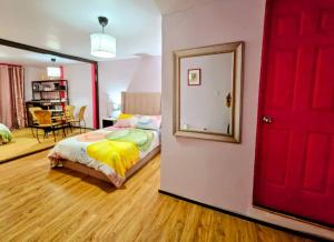 a bedroom with a red door and a mirror at Suite Rosa familiar para hasta 6 huéspedes Amplia, céntrica, con cocineta y baño privado in Mexico City