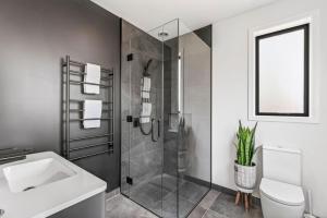 a bathroom with a shower and a toilet and a sink at Luxury Hāwea, Alfresco Retreat, Sleeps 6 in Lake Hāwea +16 photos