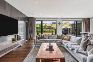a living room with a couch and a tv at Luxury Hāwea, Alfresco Retreat, Sleeps 6 in Lake Hāwea