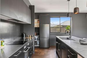 a kitchen with stainless steel appliances and a large window at Luxury Hāwea, Alfresco Retreat, Sleeps 6 in Lake Hāwea