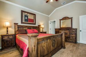 een slaapkamer met een houten bed en een spiegel bij River Ridge on the Guadalupe - Riverfront with Large Deck, Direct Float Access & Cliff Side Views in New Braunfels