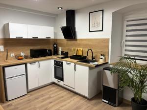 eine Küche mit weißen Schränken und einer Arbeitsplatte in der Unterkunft Apartament nad rzeką 2 in Kowary