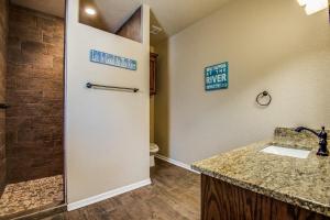 een badkamer met douche, wastafel en toilet bij River Ridge on the Guadalupe - Riverfront with Large Deck, Direct Float Access & Cliff Side Views in New Braunfels +17 foto's