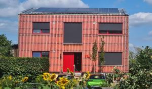 a red brick building with solar panels on it at elfA-partment in Schwanstetten