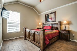 een slaapkamer met een houten bed en een raam bij River Ridge on the Guadalupe - Riverfront with Large Deck, Direct Float Access & Cliff Side Views in New Braunfels