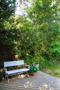 a white bench sitting on a wooden deck with plants at Villa Hjortekær in Kongens Lyngby