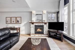 ein Wohnzimmer mit Sofa und Kamin in der Unterkunft Rivergrass Home with Mountain and Golf Course Views in Blue Mountains