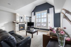 ein Wohnzimmer mit Sofa und Kamin in der Unterkunft Rivergrass Home with Mountain and Golf Course Views in Blue Mountains