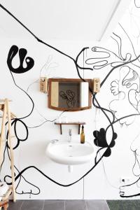 a bathroom with a sink and a wall with graffiti at De Groene Afslag Kunsthotel in Bussum +97 photos
