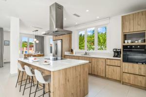 eine Küche mit Holzschränken und eine große Insel mit Barhockern in der Unterkunft DayDream Villa in Palm-Eagle Beach