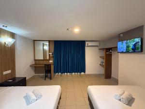 a hotel room with two beds and a flat screen tv at Hotel Putra Hills at WTCKL in Kuala Lumpur