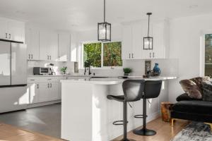 una cucina con armadi bianchi e un bar con sedie di Bayview Bliss a Canyon