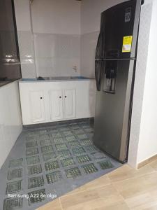 een keuken met een koelkast en een tegelvloer bij Casa punta del este in Paipa +1 foto
