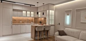 eine Küche mit weißen Schränken, einem Sofa und einem Tisch in der Unterkunft Lux Living Apartments in Plowdiw