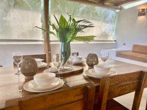 a wooden table with plates and a vase with a plant at Villa Las Malaguenas in Las Terrenas +9 photos