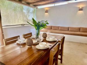 a wooden table with a vase of flowers on it at Villa Las Malaguenas in Las Terrenas