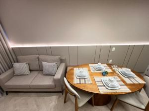 LK Centro 11 في بيلو هوريزونتي: طاولة وأريكة في غرفة صغيرة