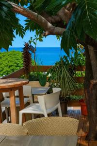 a patio with a table and chairs and the ocean at Studio confortable à Bouillante, 56 m², vue mer, jardin clos. in Bouillante