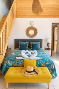 a bedroom with a bed with two swans on it at Studio confortable à Bouillante, 56 m², vue mer, jardin clos. in Bouillante