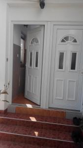 two white doors on a wall with stairs at Apartment Mehi in Pazarić