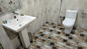 een badkamer met een witte wastafel en een toilet bij فندق جولدن نيو جوان HOTEL GOLDEN NEW jWan in Abha