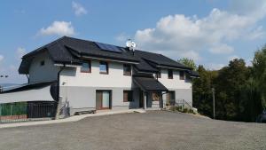a white house with solar panels on the roof at Penzión Trio in Trnkov