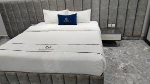 een groot bed met witte lakens en blauwe kussens bij فندق جولدن نيو جوان HOTEL GOLDEN NEW jWan in Abha +2 foto's