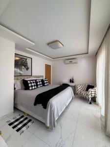 ein Schlafzimmer mit einem großen Bett und einer Couch in der Unterkunft Bela casa em Guaratiba in Mato Alto