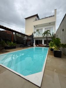 ein Swimmingpool vor einem Haus in der Unterkunft Bela casa em Guaratiba in Mato Alto
