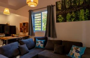 a living room with a couch and a window at Vaihi's Garden climatisé, vue sur mer - Huahine in HUH