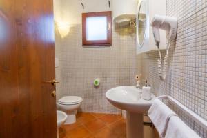 a white bathroom with a sink and a toilet at Agriturismo Il Cerrosughero in Scarlino +30 photos