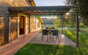 a patio with a table and chairs under a pergola at Agriturismo Il Cerrosughero in Scarlino