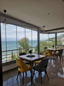 ein Restaurant mit Tischen und Stühlen und Blick auf das Meer in der Unterkunft Villa Nika Pestani in Peštani