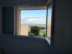 ein Fenster in einem Zimmer mit Meerblick in der Unterkunft Comfortable apartment with sea view in Le Barcarès