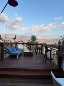 a deck with a blue couch and a giraffe statue at Las Palmas in Eilat