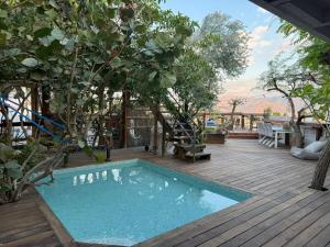 a swimming pool on a wooden deck with a tree at Las Palmas in Eilat