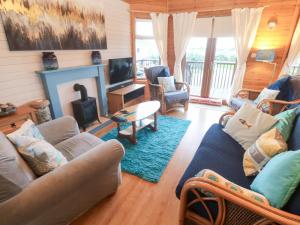 a living room with couches and a tv and a fireplace at Lamorna in Penzance