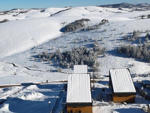 an aerial view of a snow covered mountain with buildings at HUUT in Zlatibor