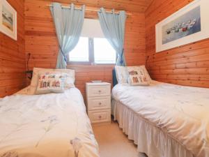 two beds in a room with wooden walls at Lamorna in Penzance +22 photos