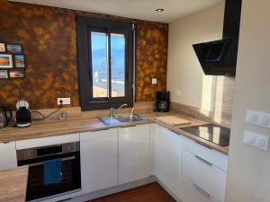 eine Küche mit einem Waschbecken und einem Fenster darin in der Unterkunft Comfortable apartment with sea view in Le Barcarès