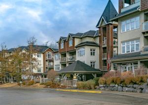a row of apartment buildings on the side of a street at Cozy 2BR-5BD Suite - Mountain Views - Htd Parking in Canmore