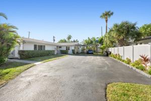 un vialetto di una casa con recinzione e palme di Villa Hanna a Lighthouse Point