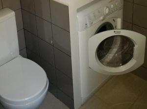 a bathroom with a toilet and a washing machine at VRS - PORTO BEACH FLAT in Porto